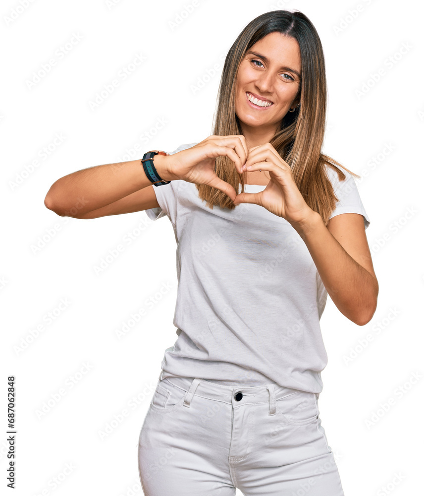 Young woman wearing casual white t shirt smiling in love showing heart symbol and shape with hands. romantic concept. Young woman wearing casual white t shirt smiling in love showing heart symbol and shape with hands. romantic concept.