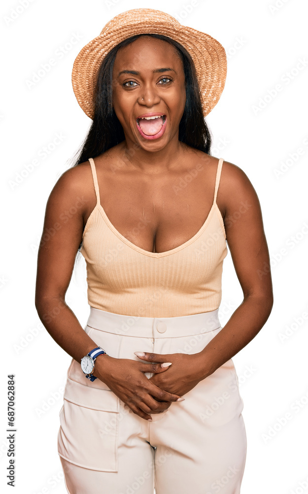 Young black woman wearing summer hat sticking tongue out happy with funny expression. emotion concept. Young black woman wearing summer hat sticking tongue out happy with funny expression. emotion concept.