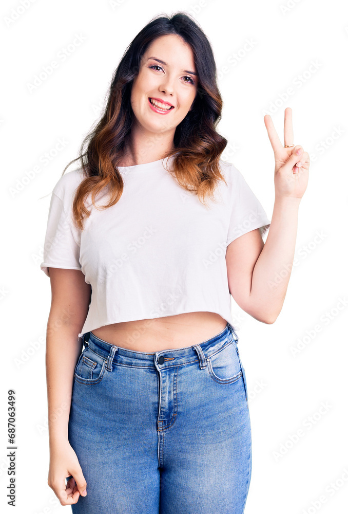 Beautiful young brunette woman wearing casual clothes smiling with happy face winking at the camera doing victory sign. number two. Beautiful young brunette woman wearing casual clothes smiling with happy face winking at the camera doing victory sign. number two.