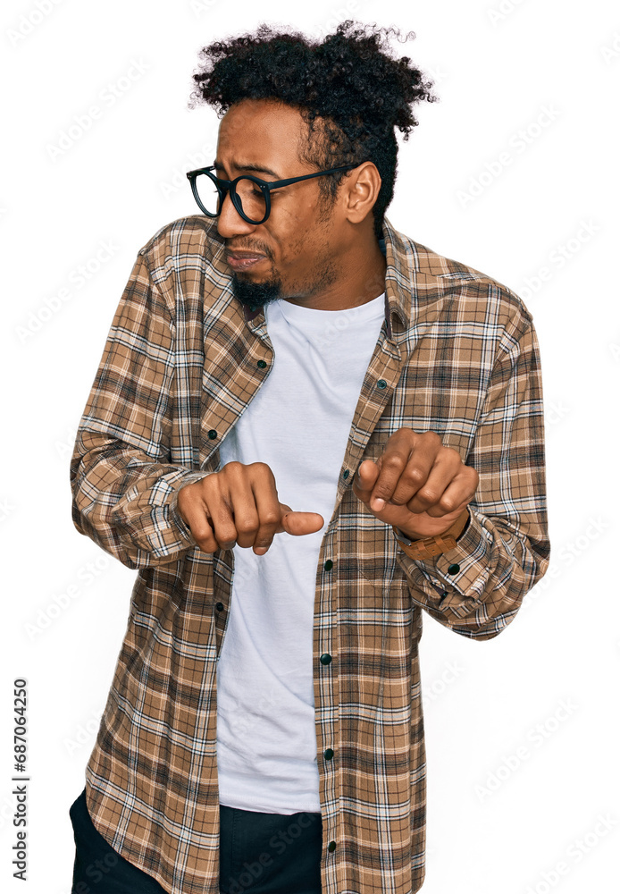 Young african american man with beard wearing casual clothes and glasses disgusted expression, displeased and fearful doing disgust face because aversion reaction. Young african american man with beard wearing casual clothes and glasses disgusted expression, displeased and fearful doing disgust face because aversion reaction.