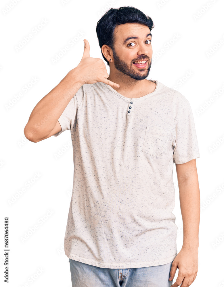 Young hispanic man wearing casual clothes smiling doing phone gesture with hand and fingers like talking on the telephone. communicating concepts. Young hispanic man wearing casual clothes smiling doing phone gesture with hand and fingers like talking on the telephone. communicating concepts.