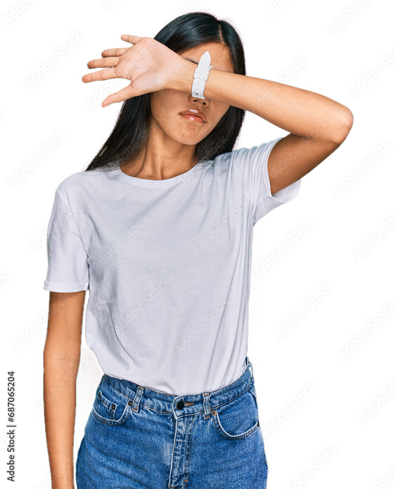 Φωτογραφία Beautiful young asian woman wearing casual white t shirt covering eyes with arm, looking serious and sad