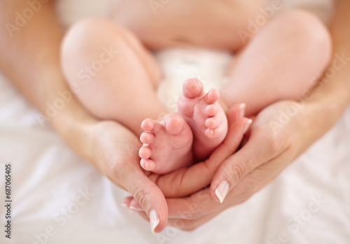 Woman, child and feet holding for love connection or childhood bonding, motherhood or newborn. Female person, infant and toes or care support for kid growth development, parent trust or nurture youth © Tabitha Rose/peopleimages.com