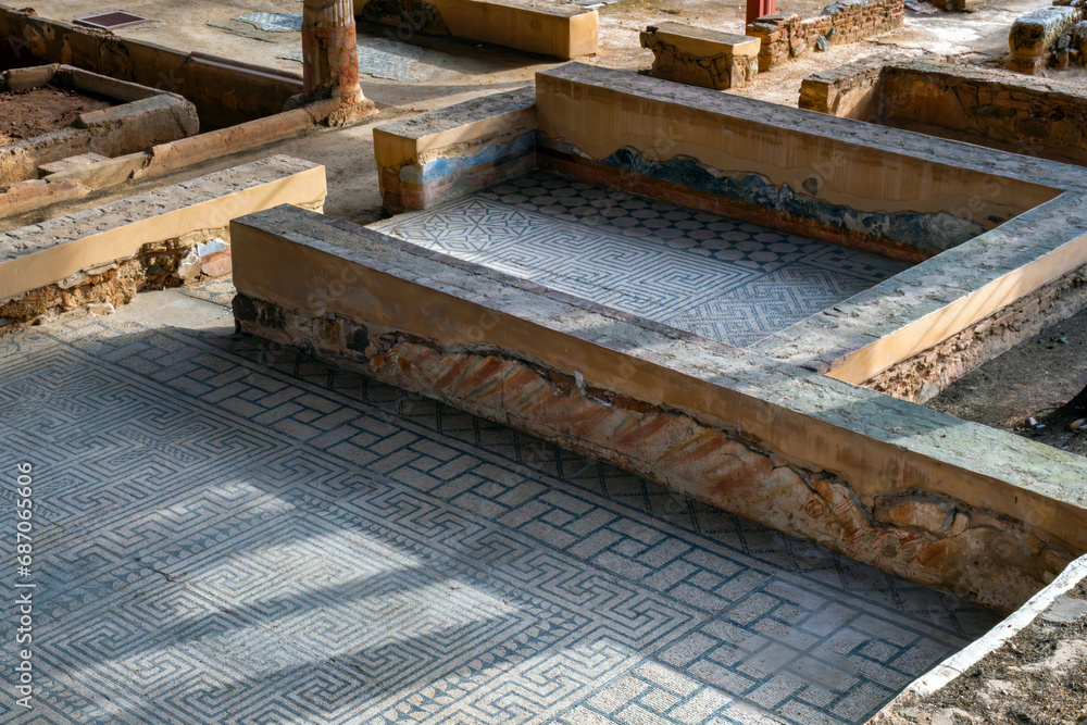 Archaeological remains of the floors of different Roman rooms with the floor decorated with mosaics with blue geometric figures that create a fractal structure in the Mitreo house in Mérida, Spain.
