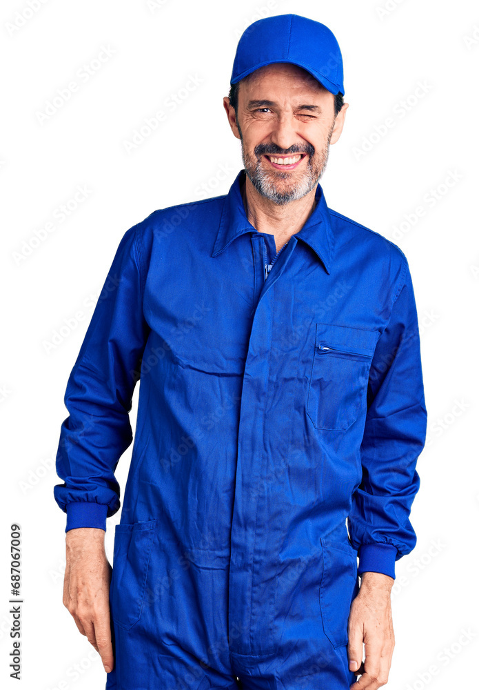 Middle age handsome man wearing mechanic uniform winking looking at the camera with sexy expression, cheerful and happy face.
