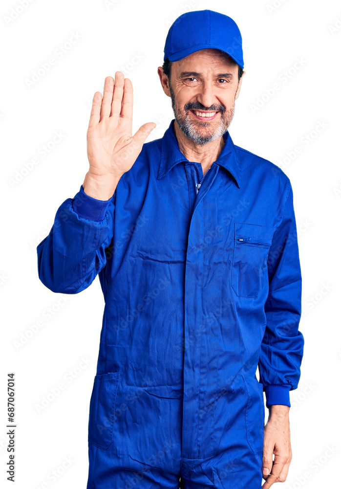 Middle age handsome man wearing mechanic uniform waiving saying hello happy and smiling, friendly welcome gesture Middle age handsome man wearing mechanic uniform waiving saying hello happy and smiling, friendly welcome gesture