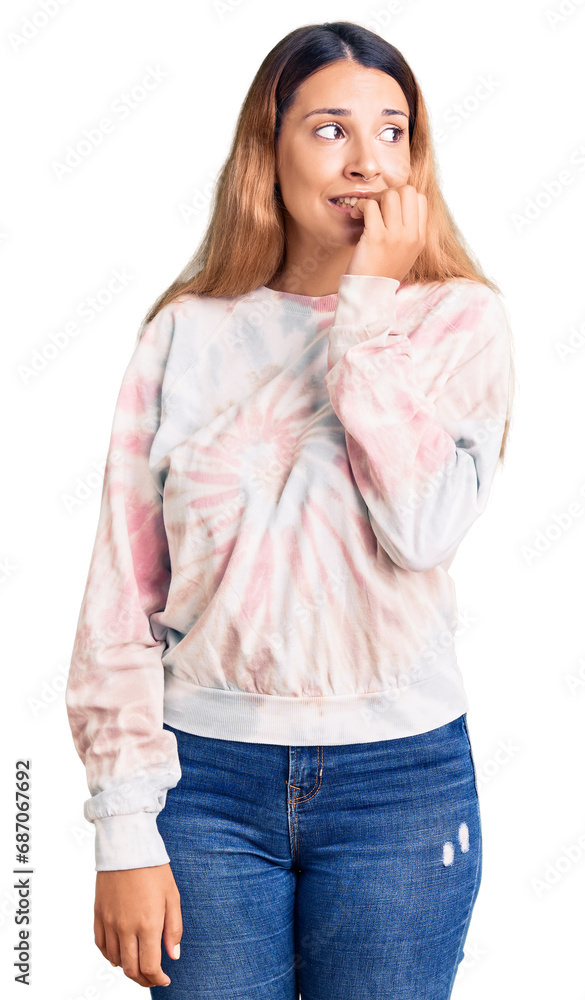 Beautiful young woman wearing casual tie dye sweatshirt looking stressed and nervous with hands on mouth biting nails. anxiety problem. Beautiful young woman wearing casual tie dye sweatshirt looking stressed and nervous with hands on mouth biting nails. anxiety problem.