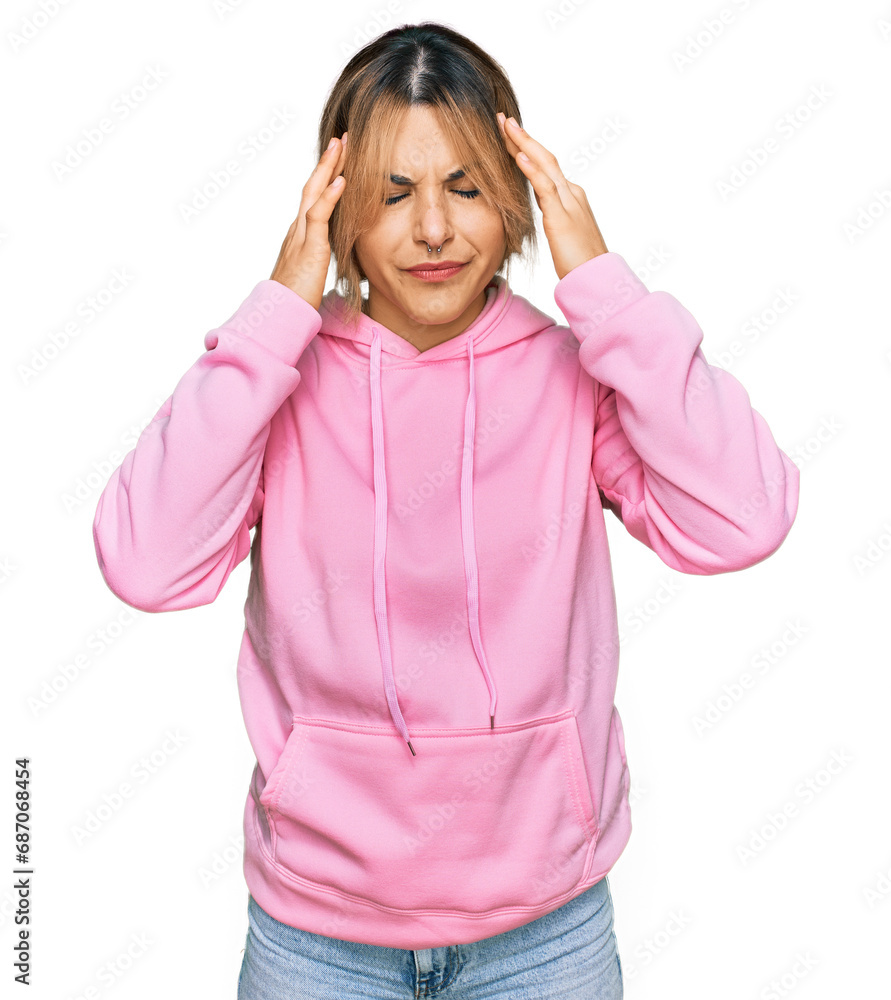 Young caucasian woman wearing casual sweatshirt with hand on head for pain in head because stress. suffering migraine. Young caucasian woman wearing casual sweatshirt with hand on head for pain in head because stress. suffering migraine.