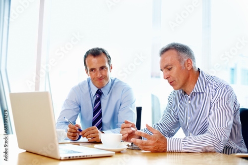 Business people, planning and teamwork on laptop for advice, support and strategy in a financial meeting. Professional manager, mature boss or men talking of revenue, sales or profit on a computer