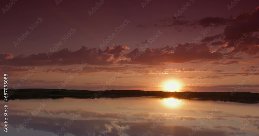 Sunrise on cloudy morning over calm lake in calm weather Sunrise on cloudy morning over calm lake in calm weather
