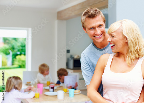 Breakfast, mother and father in hug at table in home with children eating together in morning. Healthy, food and portrait at brunch with kids, mom and dad or nutrition in diet for energy and wellness