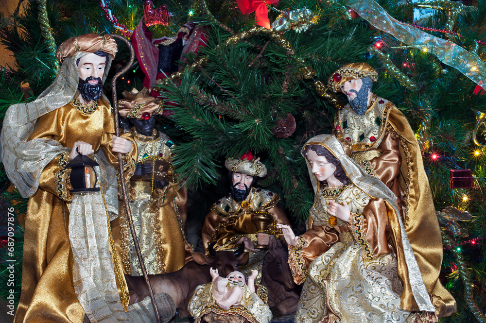Nativity scene near a decorated Christmas tree.