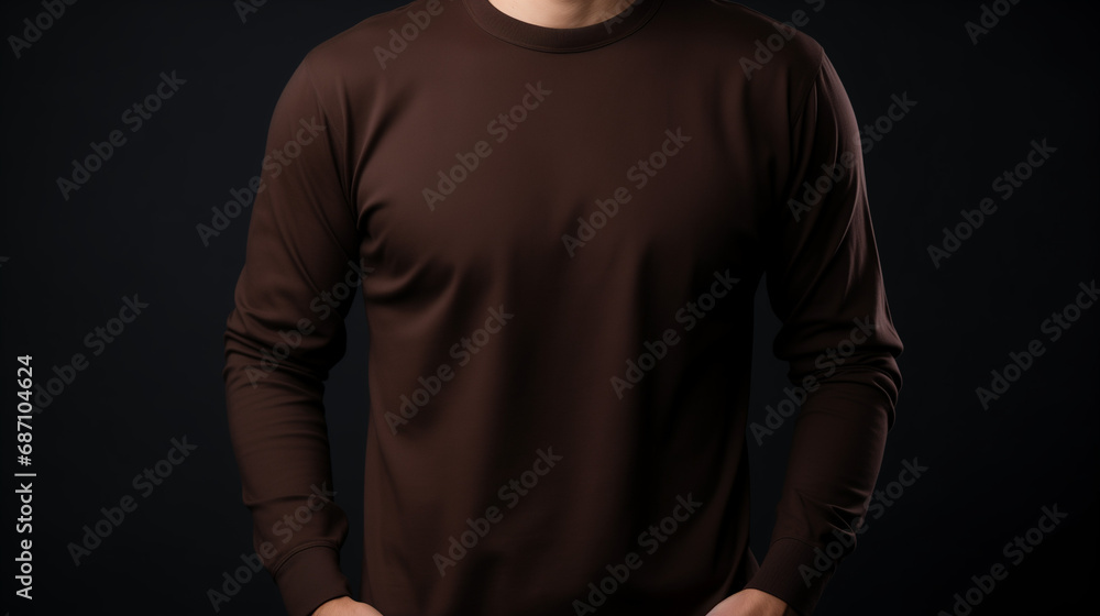 Man wearing dark brown long sleeve t-shirt, isolated in dark background Man wearing dark brown long sleeve t-shirt, isolated in dark background