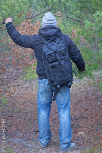 Wallpaper Mural one brack army backpack on the back of a man in a gray hat and jacket on an autumn street Torontodigital.ca