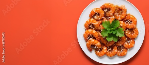 Shrimp in sauce on white plate, orange background