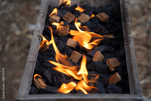 Empty barbecue flaming grill close up with bright flames and  firelighters burning photo