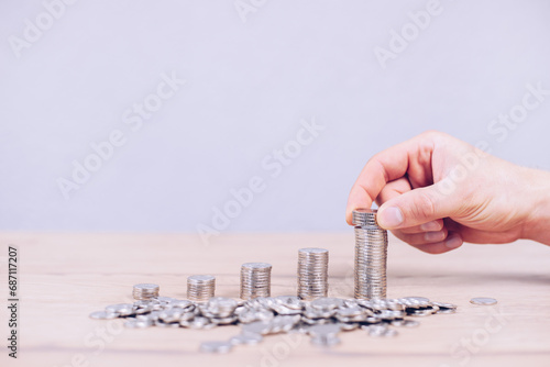 Stack of coins in ascending order. Growth of the deposit investment economy. Enrichment. The hand puts mounts. Piggy bank