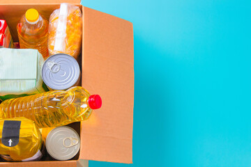 Top view to cardboard box full of grocery products. Online shopping, delivery. Food pantry. Donation, charity, food bank, help for low income, poor families, migrants, refugees, homeless