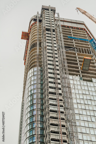 FRANKFURT, GERMANY - July 19, 2023: Construction of a skyscraper apartment block showing upper floors under construction. © cubrick