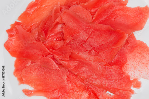 Картината върху платно Red pickled slices of ginger on white dish, close-up