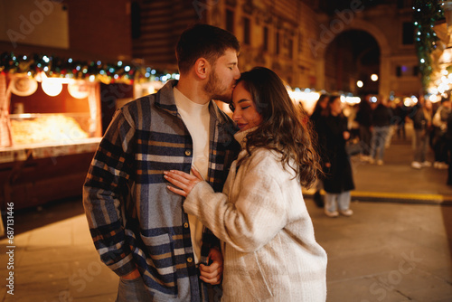 Young stylish couple in love in checkered coats in Verona at Piazza dei Signori photo