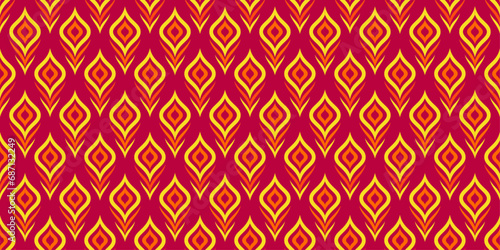 Seamless pattern of exotic peacock feathers in red and yellow colors for wallpaper and background