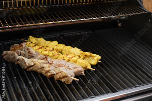 Some meat skewers being grilled in a barbecue. Shashlick laying on the grill photo
