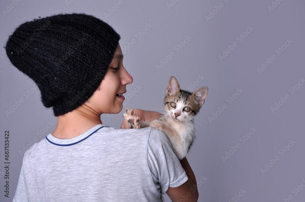Menino com gatinho doméstico fofo em retrato de estúdio 