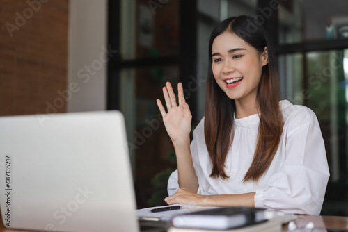 Businesswomen meeting and greeting with colleague in video call while working in outside office