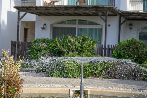 a fountain sprays water against the backdrop of a residential complex near the sea 5