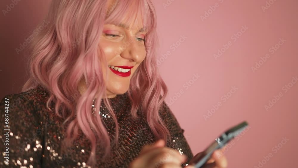 valentine day. White happy pink hair woman wear glitter dress using mobile phone while laughing isolated over pink background. High quality FullHD footage valentine day. White happy pink hair woman wear glitter dress using mobile phone while laughing isolated over pink background. High quality FullHD footage