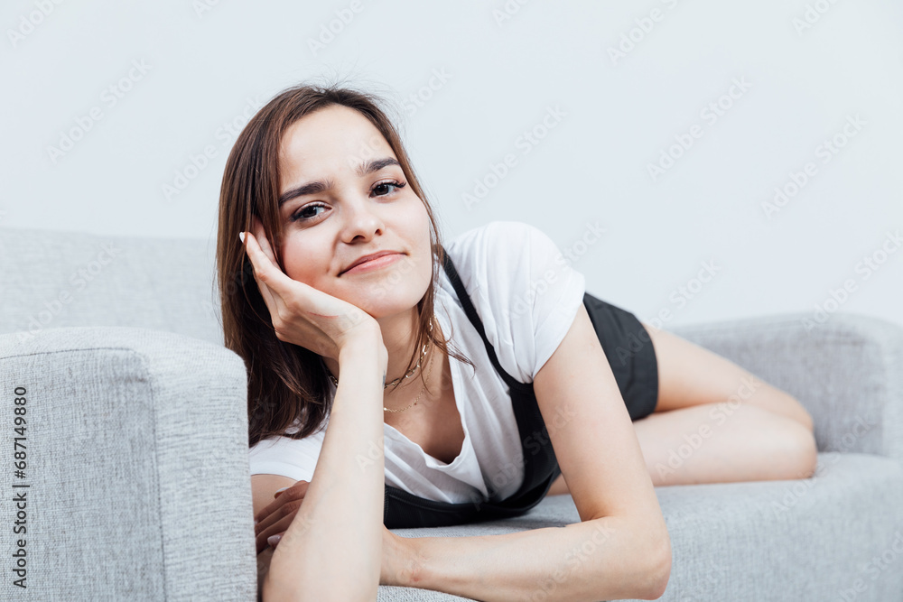 Brunette woman lying on sofa in bright room Brunette woman lying on sofa in bright room
