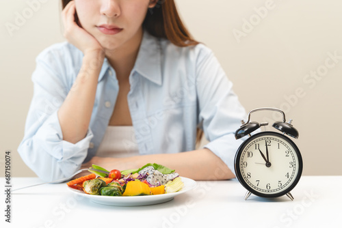 Intermittent fasting concept, Close-up on clock and people feeling hungry waiting time to eat during intermittent fasting diet session