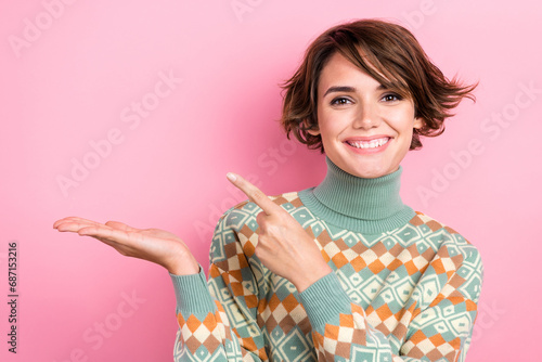 Photo of positive adorable person beaming smile direct finger arm hold empty space isolated on pink color background