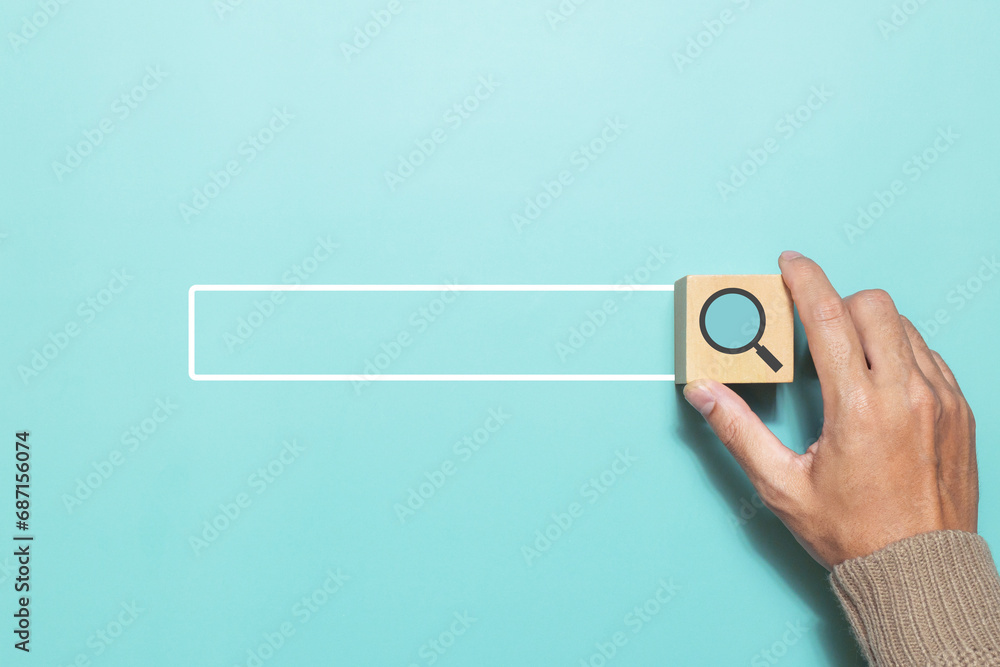 A man putting wood cube with magnifying glass icon that represents searching data information networking. Concept for network web and technology - obrazy, fototapety, plakaty 