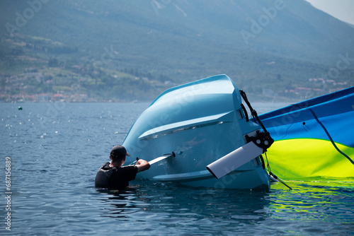 The moment of a capsizing incident during a sailing race, illustrating the technical dynamics of a boat losing its stability. the boat's heeling, loss of equilibrium, and the consequential event photo