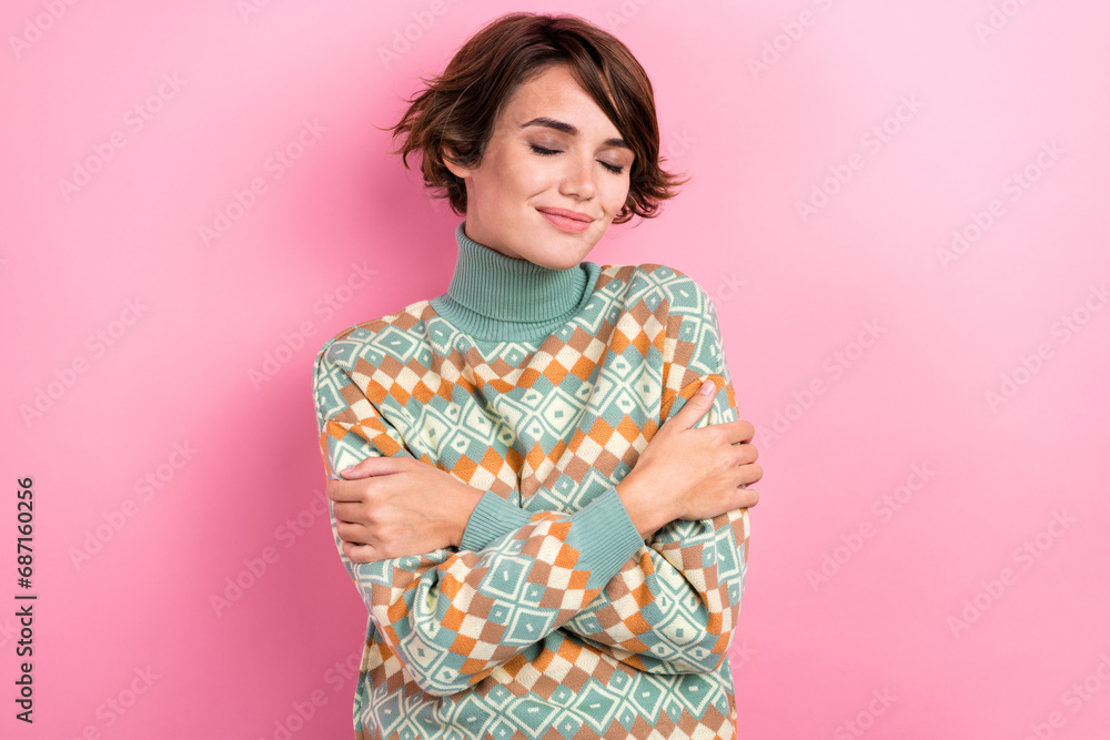 Portrait of attractive young girl wearing ornament stylish sweater hugs herself close eyes comfortable isolated on pink color background Portrait of attractive young girl wearing ornament stylish sweater hugs herself close eyes comfortable isolated on pink color background