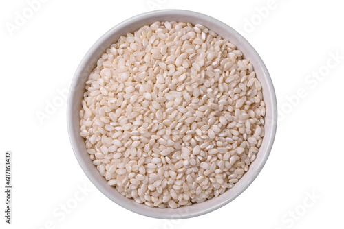 White uncooked rice in a round ceramic bowl on a dark concrete background