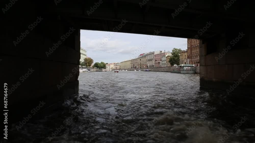 Under bridge passes ship channel - arch bridge structure. Picturesque stone embankment of St. Petersburg, Russia. View from the river Under bridge passes ship channel - arch bridge structure. Picturesque stone embankment of St. Petersburg, Russia. View from the river
