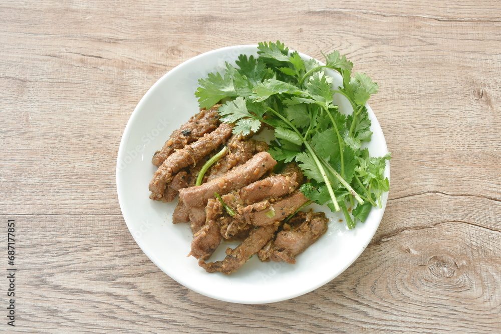 fried slice pork meat with garlic couple pepper topping parsley on plate fried slice pork meat with garlic couple pepper topping parsley on plate