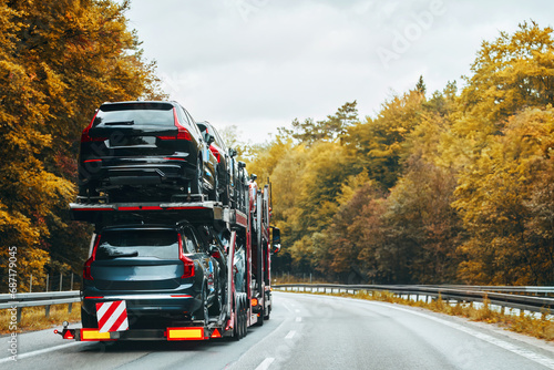 Fotografie A car with a broken engine on the road, being towed by a truck to a repair shop, as part of the roadside assistance and vehicle recovery service