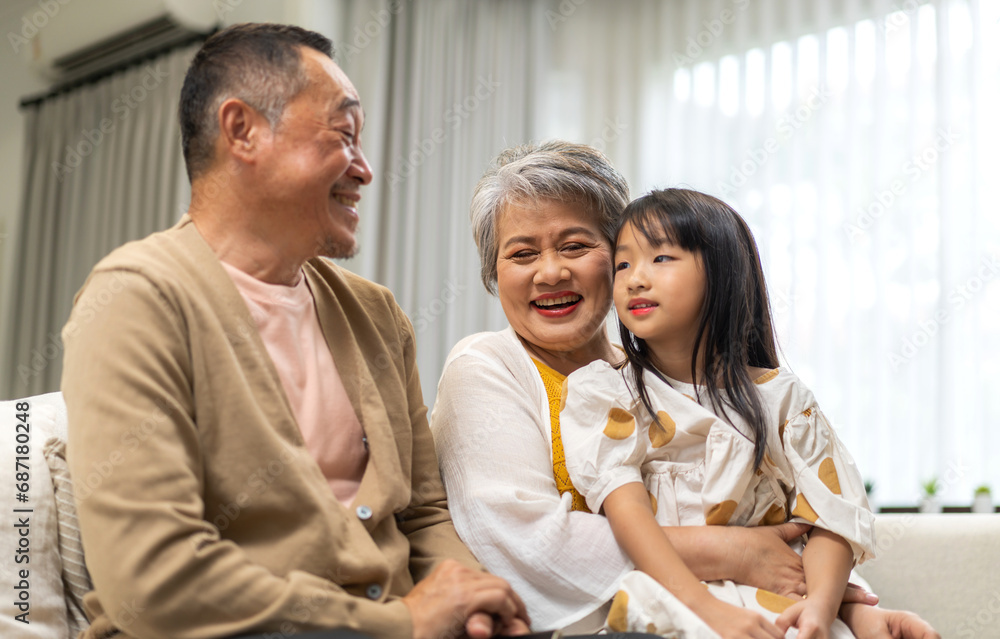 Portrait of happy love asian grandfather with grandmother and asian little cute girl enjoy relax at home.Young girl with their laughing grandparents smiling together.Family and togetherness Portrait of happy love asian grandfather with grandmother and asian little cute girl enjoy relax at home.Young girl with their laughing grandparents smiling together.Family and togetherness