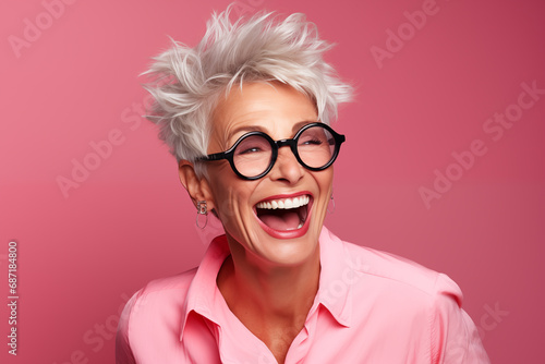 Femme senior, heureuse et souriante portant des lunettes, arrière-plan isolé de couleur rose. photo