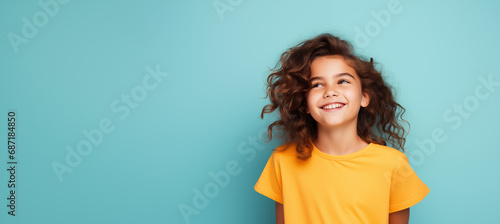 Une jolie petite fille heureuse et souriante, arrière-plan coloré uni, image avec espace pour texte. photo