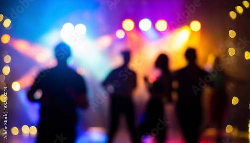 blurred background of people dancing at a music festival on stage.