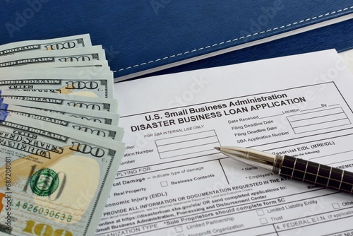 Small business Administration Disaster Business loan application form on the office table with pen and dollar bills