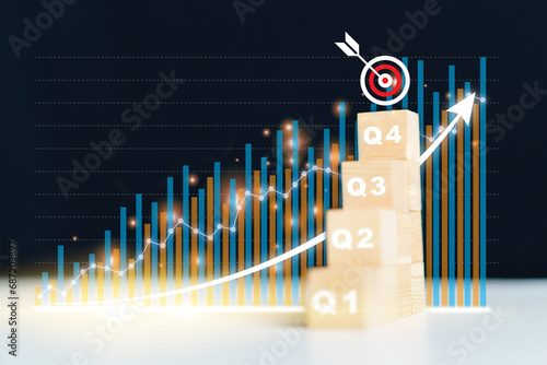 Stacked wood blocks showing a number of quarter Q1, Q2, Q3, and Q4 and beautiful virtual - holographic business graph.
