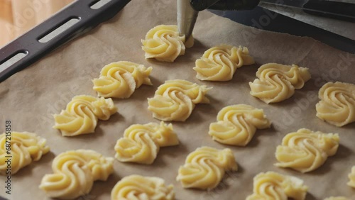 Shortbread. The cooking process. Shaping shortbread with a pastry bag. A confectioner forms cookies on a metal baking tray. Dynamic shooting