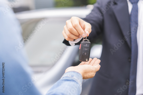 Business car rental, sell or buy service, dealership hand of agent dealer, sale man giving auto key of vehicle to customer renter, buyer young woman receiving, client or tenant, transfer automobile.