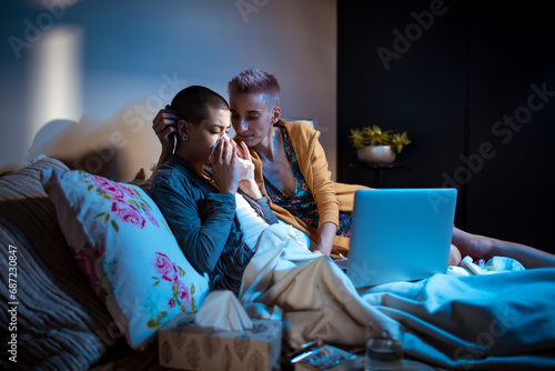 Young woman helping her sick girlfriend in the bedroom photo
